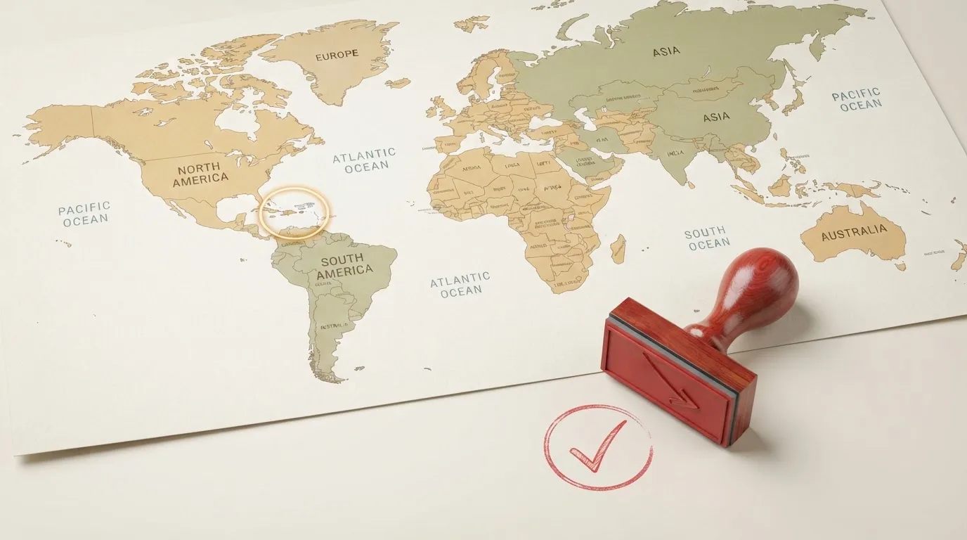 Symbolbild einer Weltkarte mit einer markierten Karibikinsel und einem daneben liegenden Stempel.